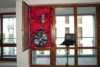 Badanie szczelności mieszkania - urządzenie Blower Door zamontowane w oknie